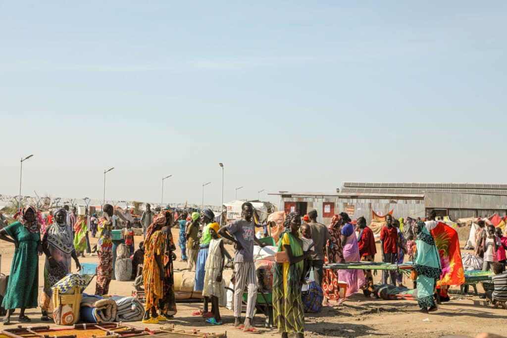 A group of women and men in Sudan gathering outside an aid facility